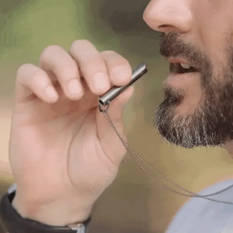A person demonstrating a gentle exhale through the Classic Harmonica breathing pendant